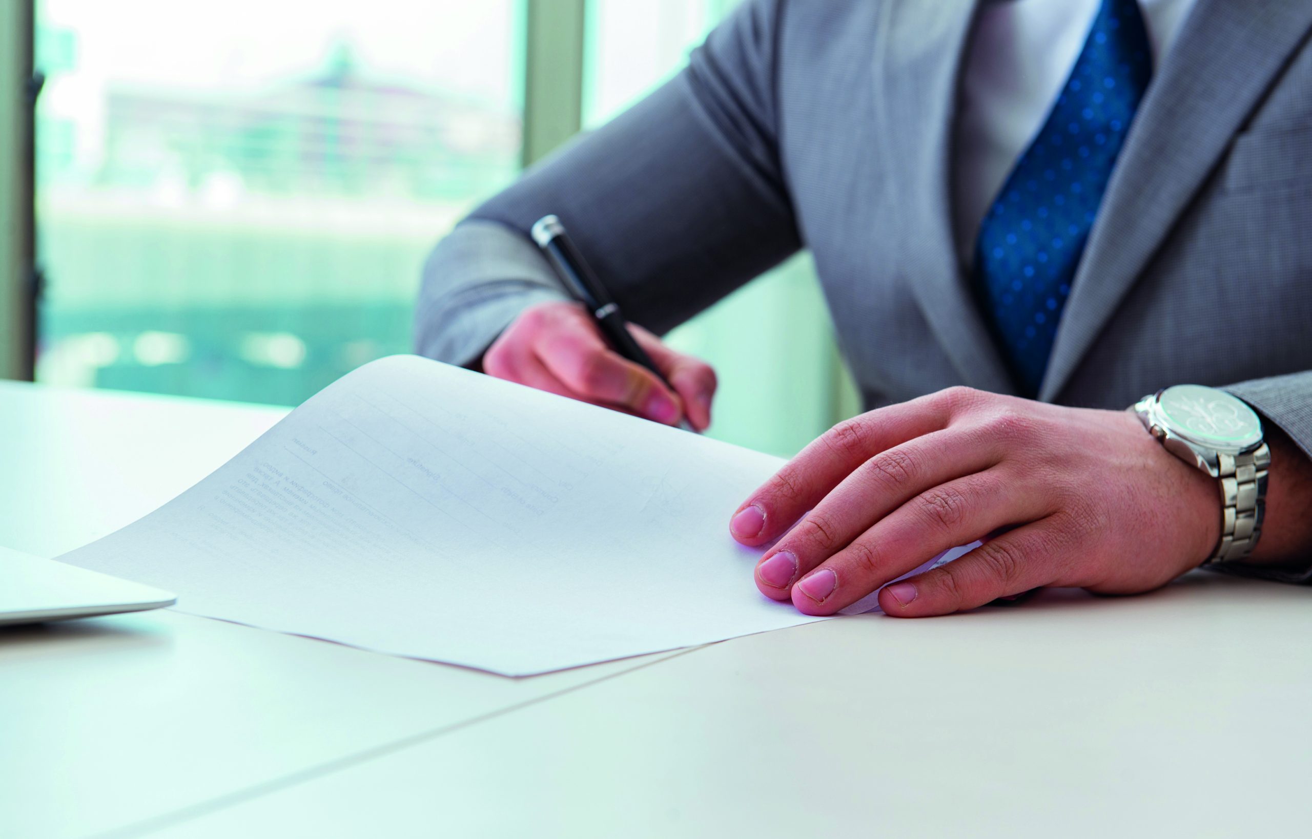 Man sitting at desk writing on paper to represent Labour's new Make Work Pay employment plan